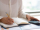 Business expert analyzing reports and counting expenses. Female accountant sitting at table with paper diagrams, writing in notebook and using calculator. Accounting concept